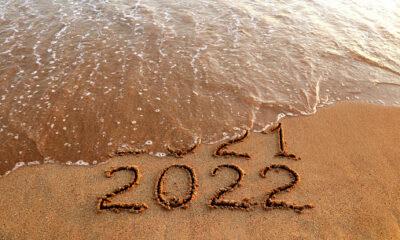 New year 2022 and old year 2021 on sandy beach with waves